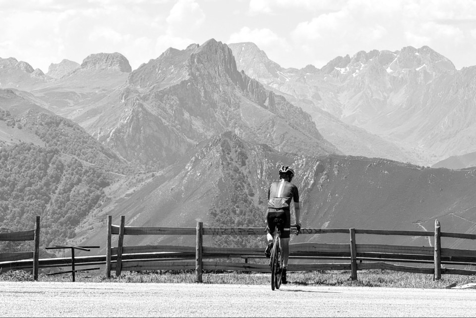 cyclist viewing picos mountains peaks ahead at climb summit on marmot tours road cycling holiday asturias pics de europa northern Spain