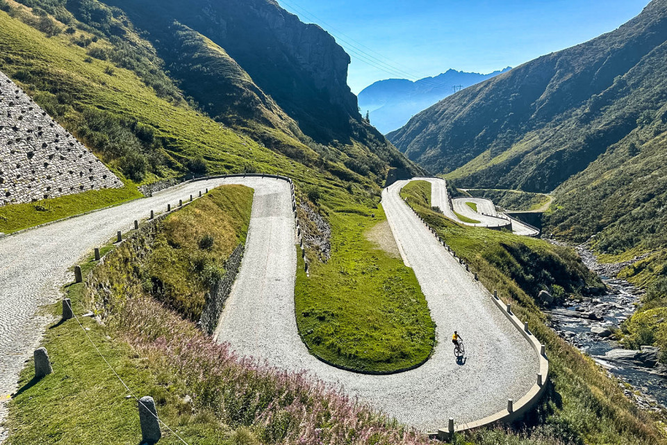 Cyclist descending cobbles of Tremola Road St Gotthard pass on Raid Dolomites cycling challenge with Marmot Tours