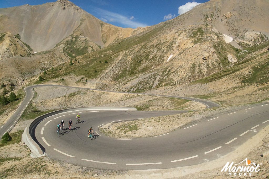 Group of cyclists climbing Col d'Izoard on Raid Aline cycling challenge with Marmot Tours