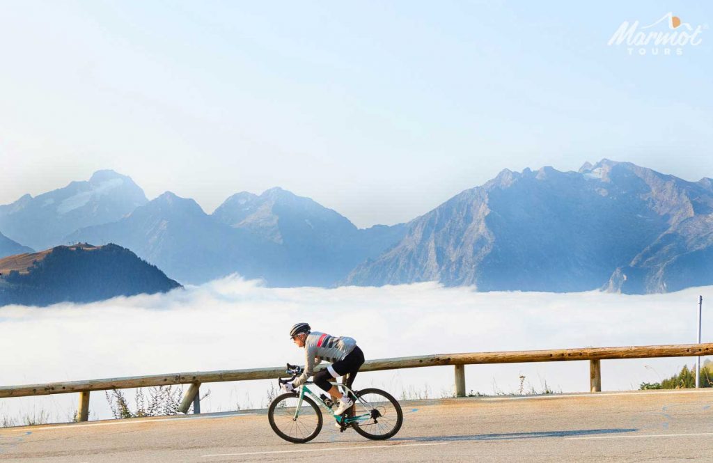 Cyclist above the clouds descending on Marmot Tours Alpine road cycling holiday