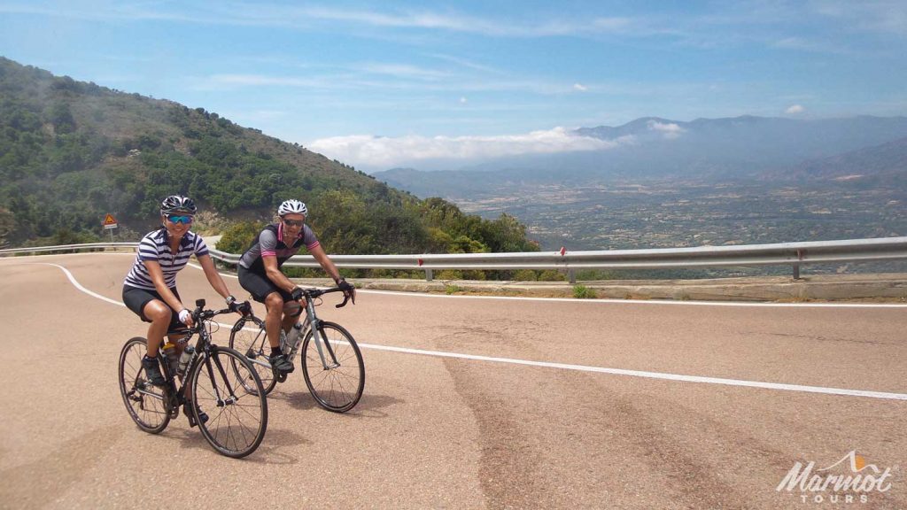 Couple enjoying great roads cycling in Sardinia with Marmot Tours