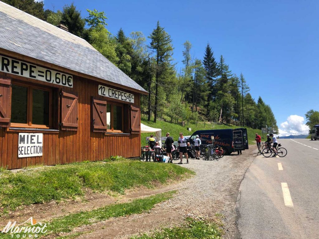 Cyclists at cafe on Col de Peyresourde Raid Pyrenean cycling challenge with Marmot Tours support van