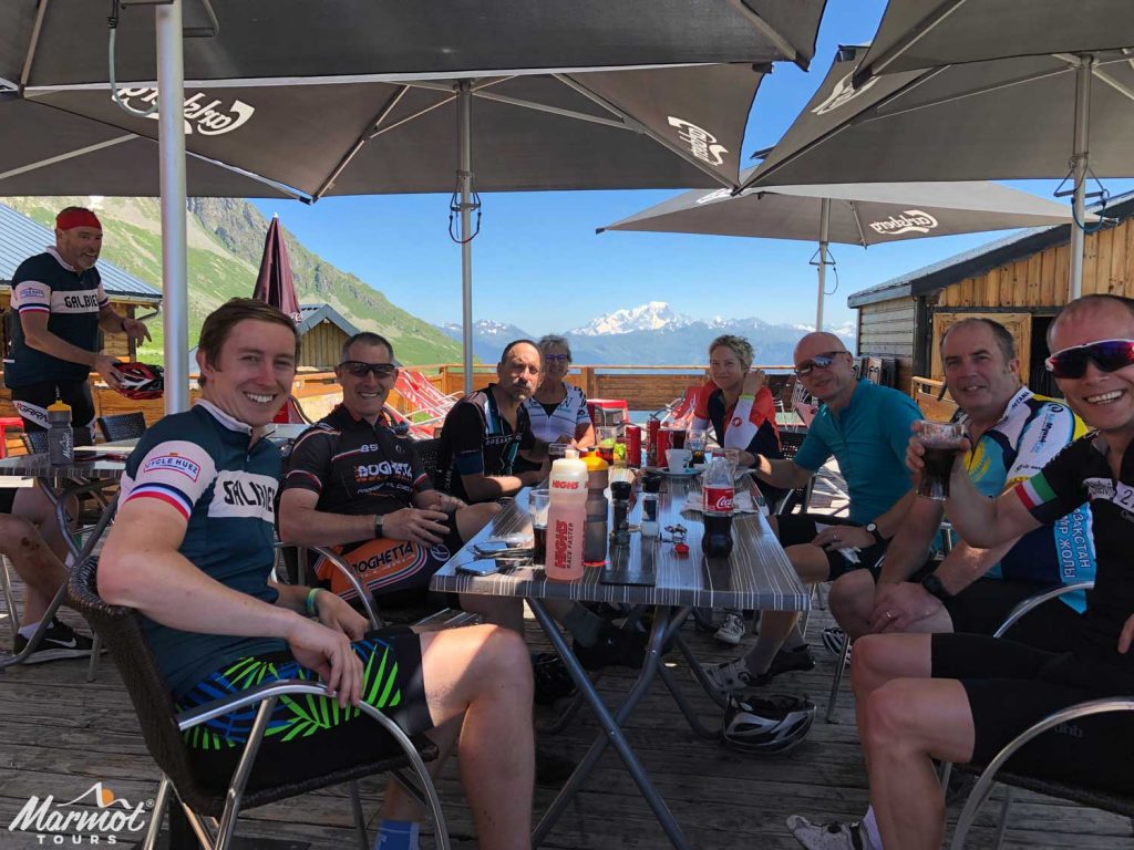 Cyclists with drinks at a bar with mountain views on Marmot Tours guided cycling holidays in the Alps
