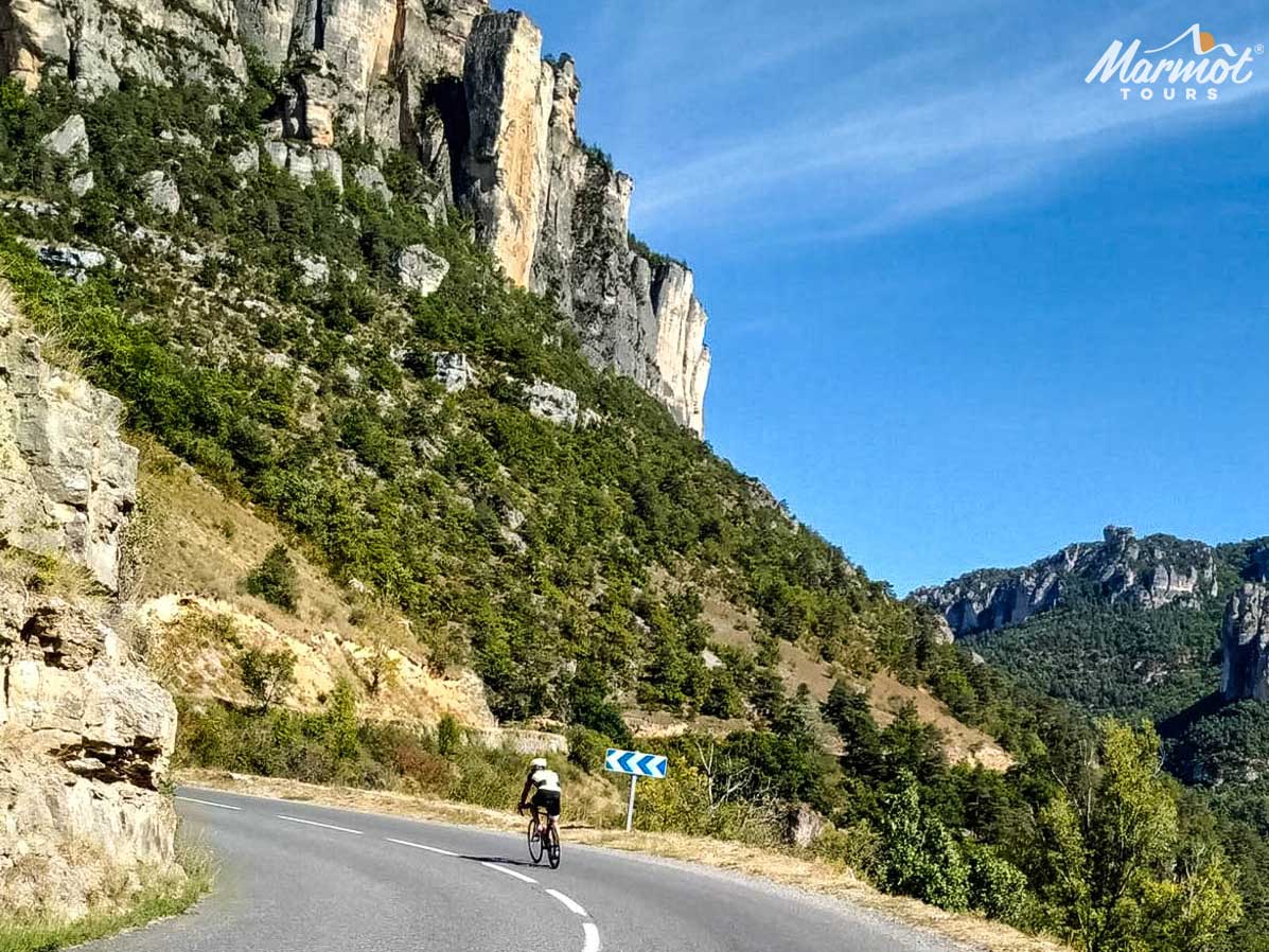 Cyclist on cliff road Gorge du Tarn road cycling in France with Marmot Tours