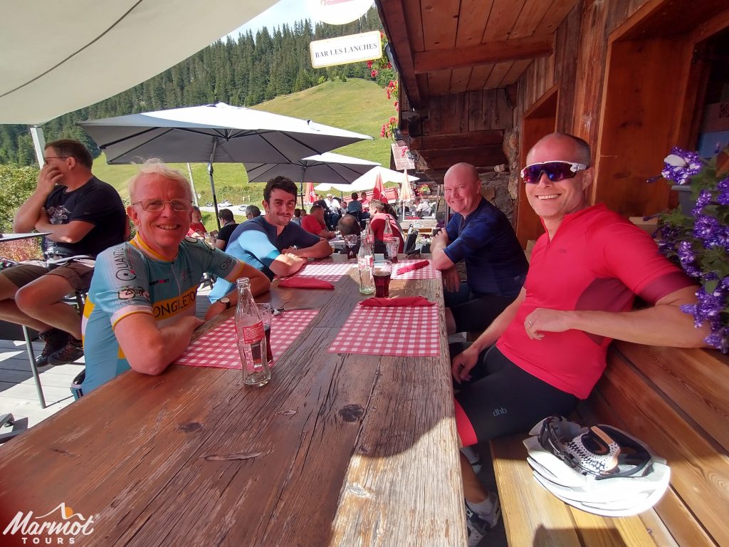 Four cyclist enjoying a drink in Alpine cafe on Marmot Tours guided French cycling holiday