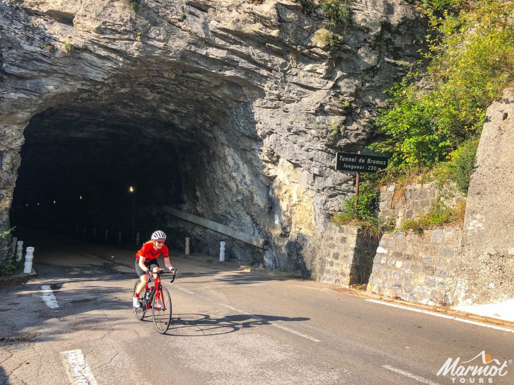 Female cyclist emerging from tunnel in the French southern alps on Marmot Tours European guided road cycling holiday