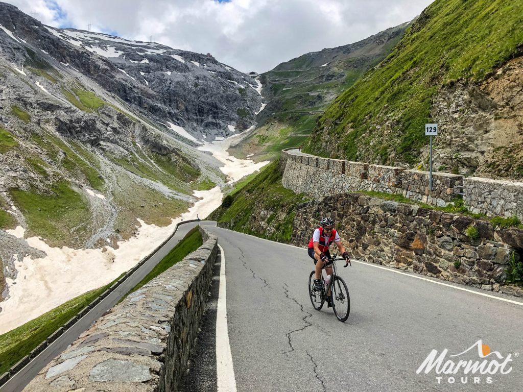Cyclist climbing Passo dello Stelvio hairpin bends with Marmot Tours guided road cycling holiday in Italy
