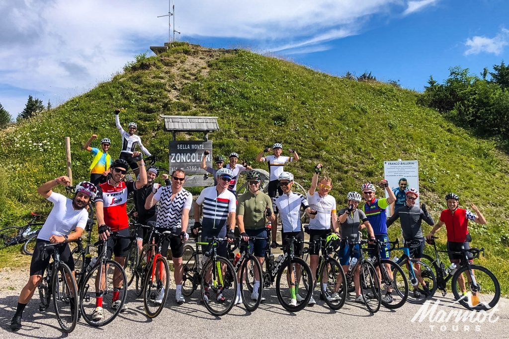 Group of cyclists celebrating at summit of Monte Zoncolan on Marmot Tours fully supported road cycling holiday Slovenia Austria Italy