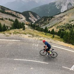 Cyclist climbing on Raid Alpine on Marmot Tours road cycling challenge in Europe