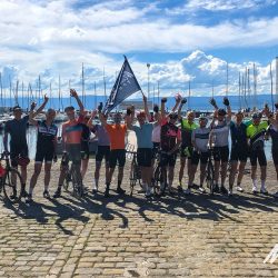 Group of cyclists at finish of Raid Alpine cycling challenge with Marmot Tours guided road cycling holidays in Europe