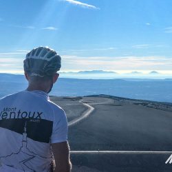 Cyclist at summit of Mont Ventoux viewing landscape with Marmot Tours