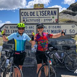 Two female cyclists celebrate at Col de l'Iseran on Marmot Tours guided cycling tour of French Alps