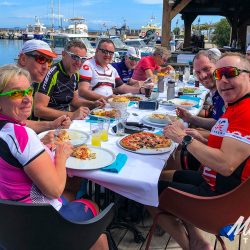 Cyclists in harbour restaurant on Marmot Tours guided road cycling holiday in Corsica