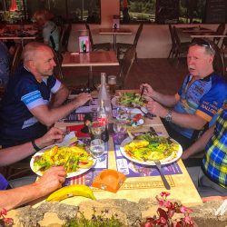 Cyclist enjoying cafe lunch on guided road cycling holiday Cevennes and Ardeche South of France Marmot Tours