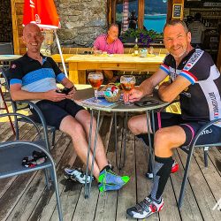 Pair of cyclists enjoying beers in baron Marmot Tours Raid Alpine cycling challenge French Alps