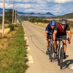 Pair of cyclists enjoying rare flat road on Marmot Tours Raid Massif Central French cycling holidays