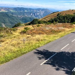 Cyclist on quiet road with open moorland on Marmot Tours Raid Massif Central French cycling holidays