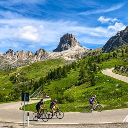 Cyclists cornering hairpin bend on Passo Giau on Marmot Tours guided road cycling holiday Dolomites Italy