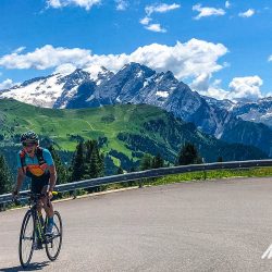 Female cyclist laughing on a climb in Dolomites Italy on marmot Tours guided cycling tour