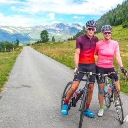 Cycling couple smiling for camera on guided road cycling holiday in French Alps with Marmot Tours