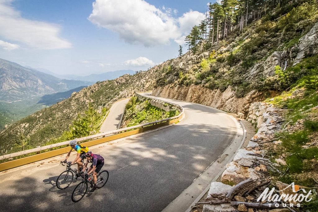 Pair of cyclists enjoying cycling climb and switchbacks in Corsica with Marmot Tours guided road cycling holidays