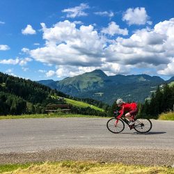 Female cyclist enjoying descent of Joux Plane Morzine cycling climb French Alps with Marmot Tours