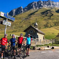 Group of cyclists with blue sky at Col d'Aravis with Marmot Tours guided road cycling in Northern French Alps