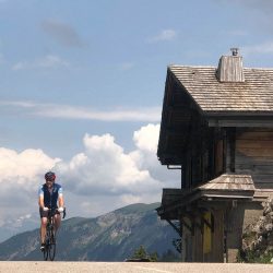 Pair of cyclists summiting Cole de la colombiere climb with Marmot Tours guided road cycling holidays French Alps