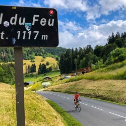 Cyclist summiting Col du Feu climb with Marmot Tours guided road cycling holiday French Alps