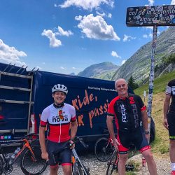Group of cyclists smiling at Col de la Colombiere sign on Marmot Tours guided road cycling holiday Northern French Alps