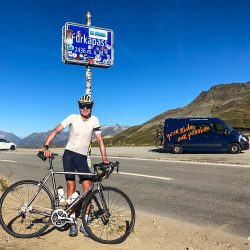 Cyclist posing with bike at Furka pass summit on Marmot Tours guided road cycling tour Swiss Alps