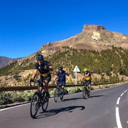 Cyclists smiling on sunny climb air punching on guided road cycling tour Tenerife with marmot Tours road cycling holidays