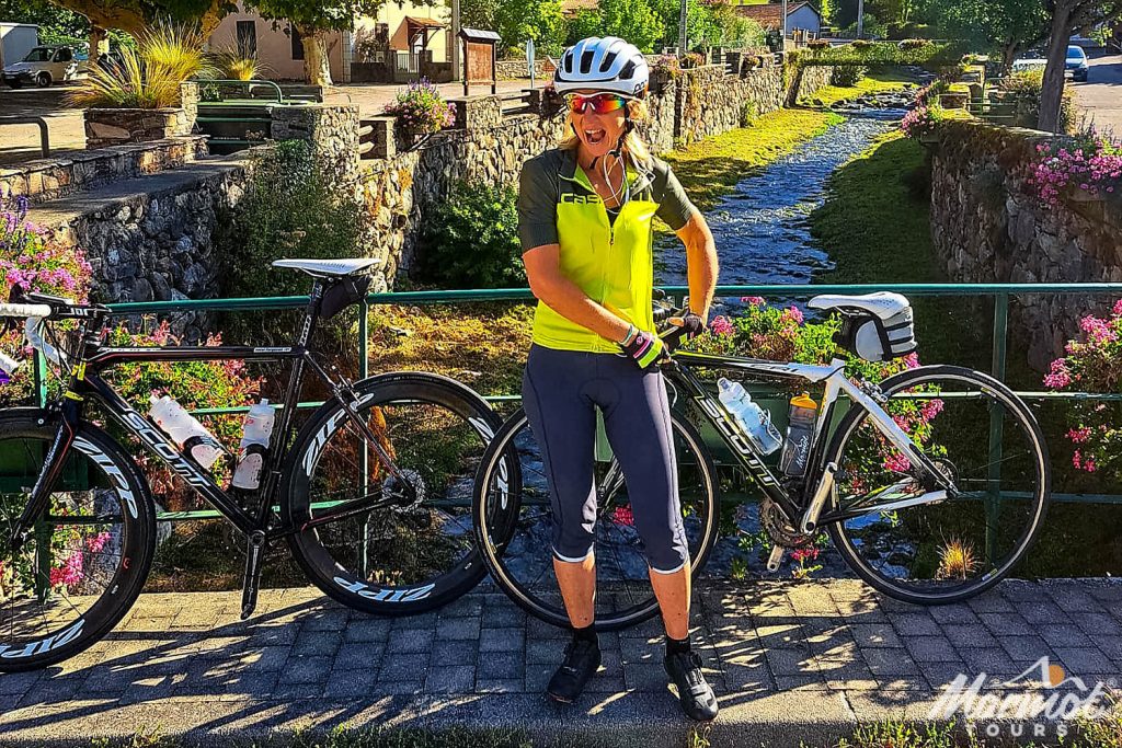 Emma Tiptaft Marmot Tours cycling guide with bikes on bridge over stream