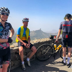 Group of cyclists smile for photo at Roque Nublo viewpoint on full support road cycling tour Gran Canaria