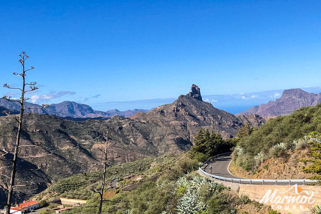 Cyclist climbing with Roque Nublo backdrop on Gran Canaria full support cycling holiday with Marmot Tours