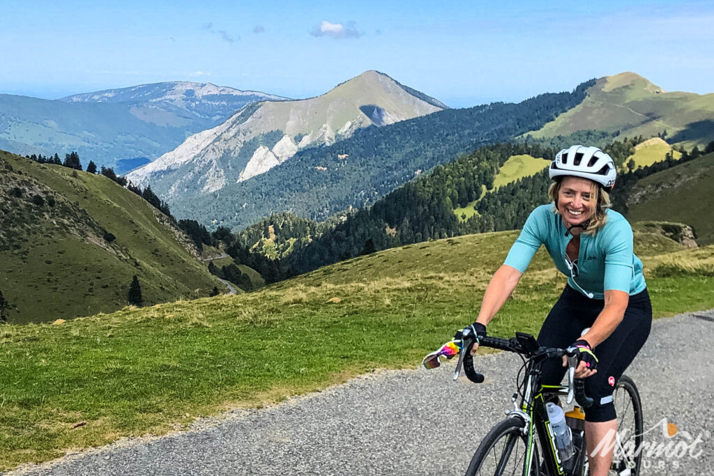 Female cyclist riding with mountain backdrop on Marmot Tours guided road cycling holiday French Pyrenees