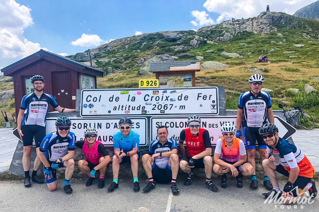 Group of cyclists posing at the Croix de Fir on marmot Tours guided road cycling tour French Alps