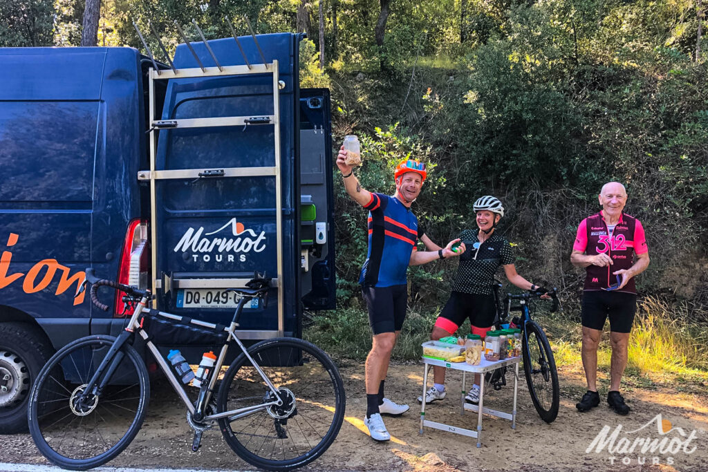 Trio of cyclists enjoy snacks from Marmot Tours support vehicle on guided European road cycling tour