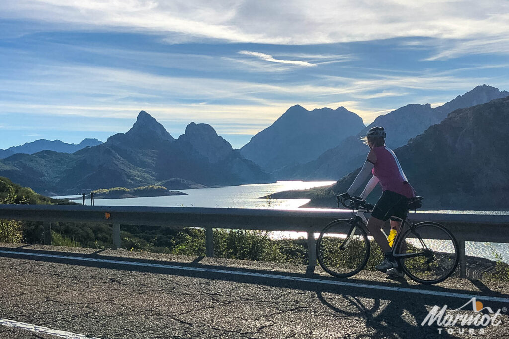 Female cyclist looking at lakes and mountains in the Picos Northern Spain on Marmot Tours guided road cycling holiday