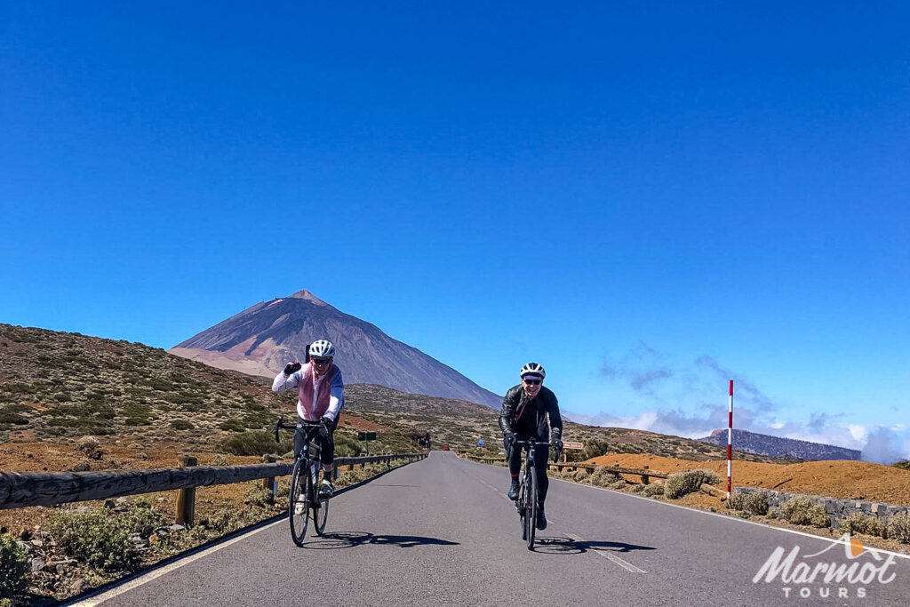 Pair of cyclists with Mt Teide in background on guided road cycling tour Tenerife with Marmot