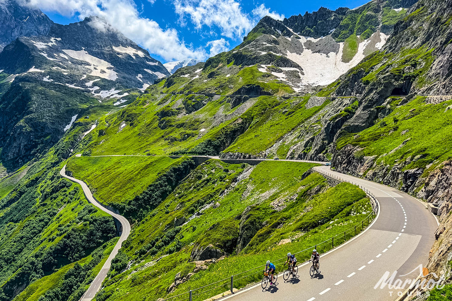 Three cyclists climbing high mountain pass on guided Swiss Alps cycling holiday with Marmot Tours