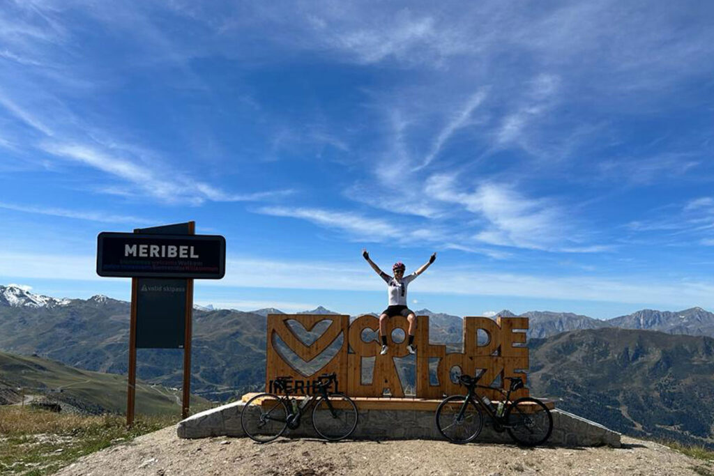 Cyclist sitting on Col de la Loze sign in Meribel on Marmot Tours guided road cycling tours Northern French Alps