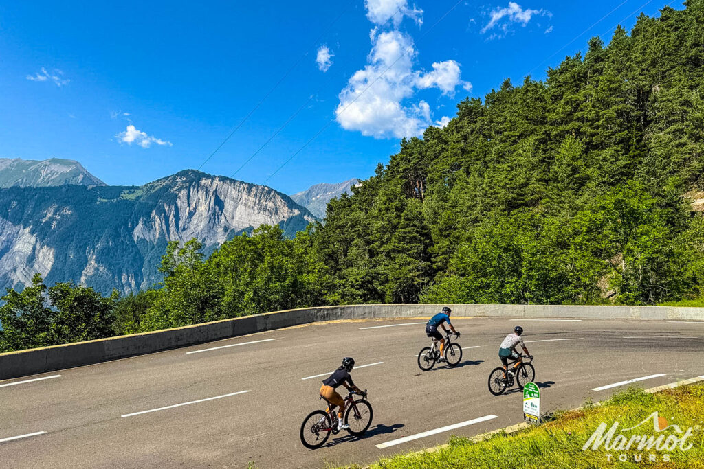 Three cyclists climbing Alpe d'Huez on French Alps cycling holiday with Marmot Tours