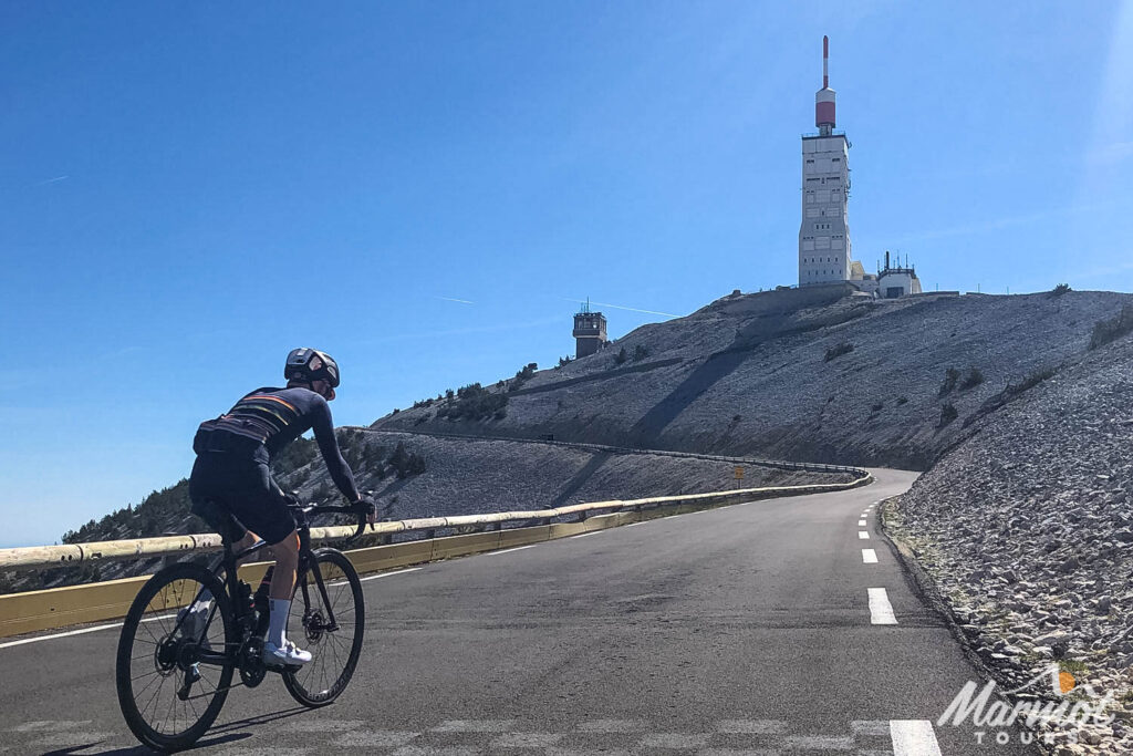 Cyclist climbing Mont Ventoux approaching summit with weather beacon in sight on Marmot Tours guided road cycling holiday club des cinglés challenge