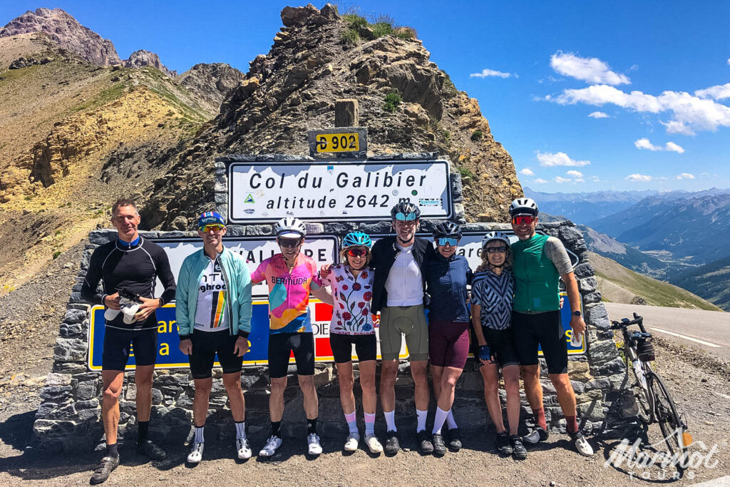 Group of cyclists posing for photo at Col du Galibier on Raid Alpine French Alps cycling holiday with Marmot Tours