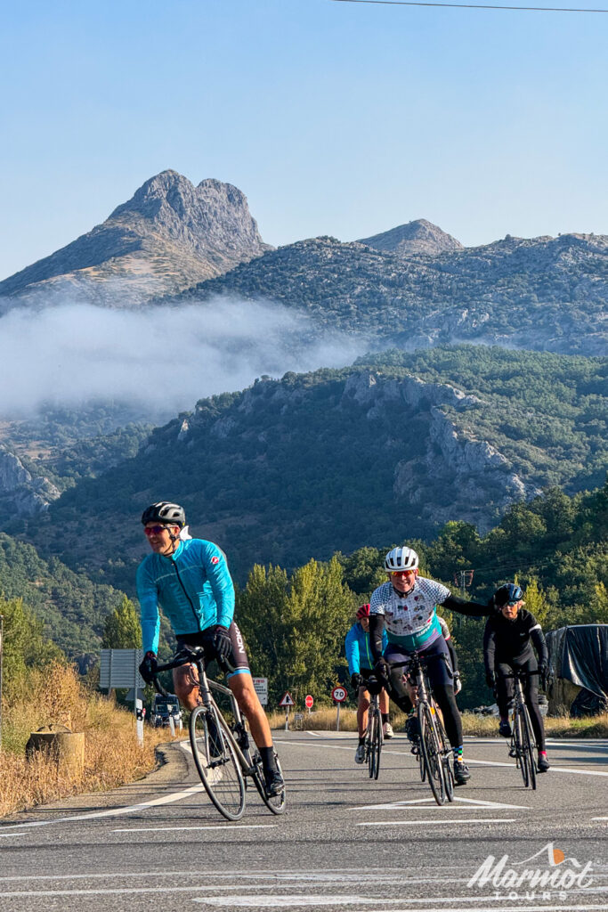 Group of cyclists with forested mountains backdrop on Marmot Tours guided road cycling tour Picos Spain