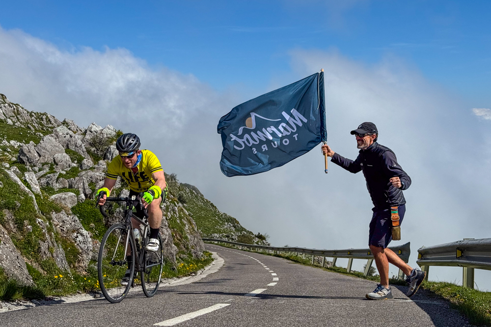 David Sota Marmot Tours cycling guides supporting cyclist summiting Angliru climb