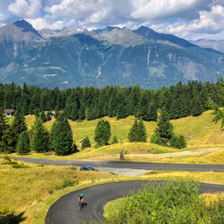 Cyclist climbing winding road with mountains background on Marmot Tours full support road cycling holiday Italian Dolomites