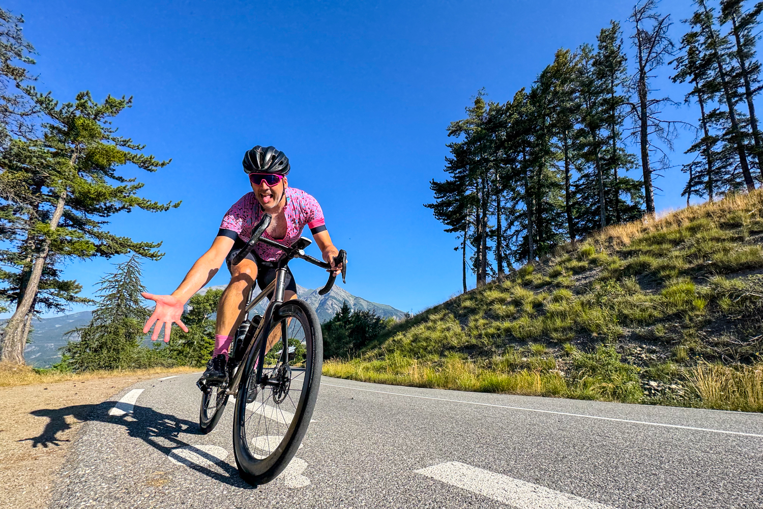 Cyclist waving and poking tongue at camera on Marmot Tours guided cycling holiday