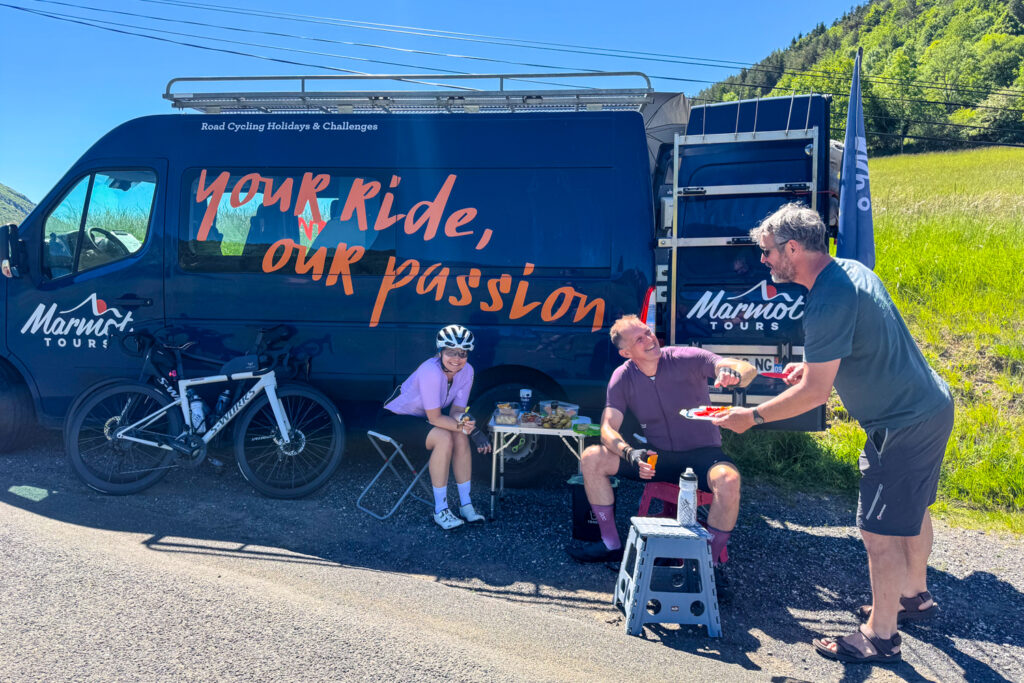 Marmot Tours guided offering fruit to resting cyclists by support vehicle